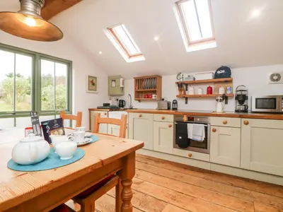a kitchen with a wooden table in a room at Hay Loft in Camborne