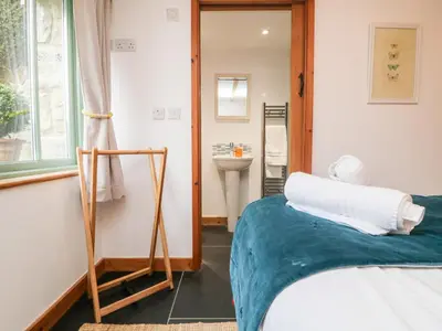 a bedroom with a bed and a sink and a mirror at Hay Loft in Camborne