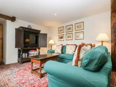 a living room with two blue couches and a television at Glanville House in Mevagissey