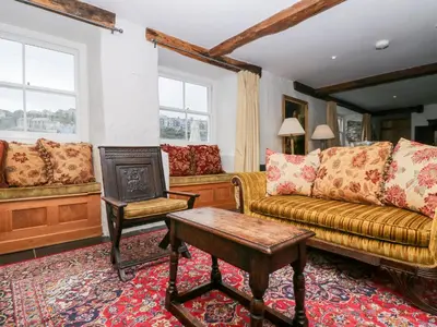 a living room with a couch and a table at Glanville House in Mevagissey