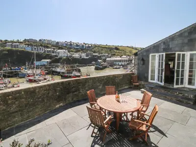 a table and chairs on a patio with a marina at Glanville House in Mevagissey