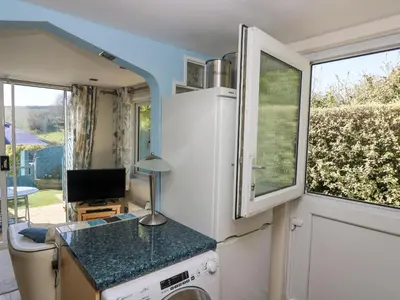 a kitchen with a white refrigerator and a window at Respryn in Mevagissey