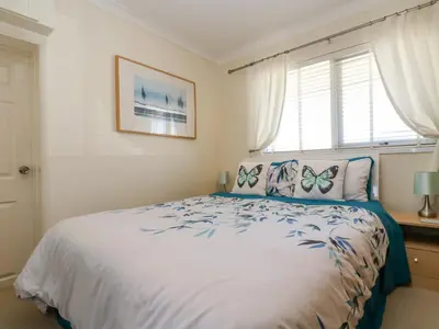 a bedroom with a bed with butterfly pillows and a window at Respryn in Mevagissey