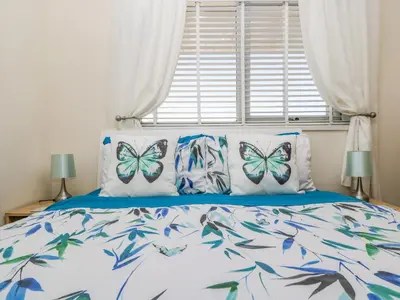 a bedroom with a bed with butterflies on the pillows at Respryn in Mevagissey