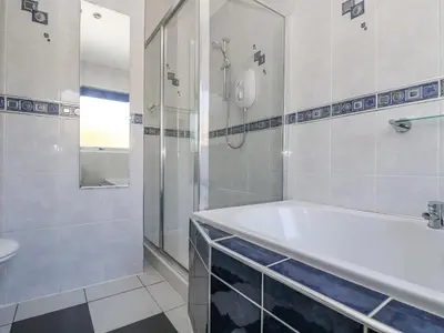 a bathroom with a tub and a shower and a sink at Respryn in Mevagissey