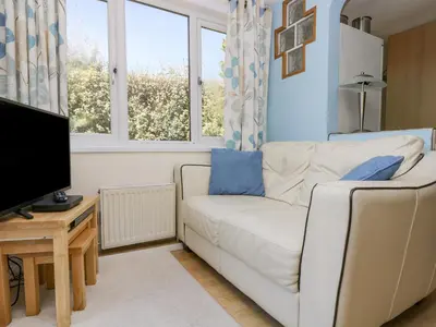 a living room with a white couch and a tv at Respryn in Mevagissey