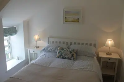 a bed in a bedroom with two lamps on two tables at Hillside Cottage in Wadebridge