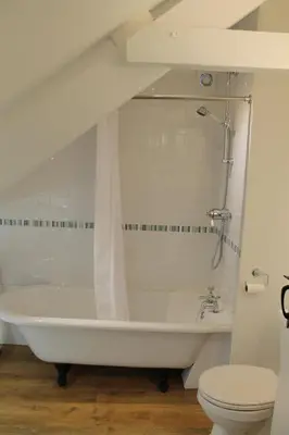 a white bathroom with a tub and a toilet at Hillside Cottage in Wadebridge