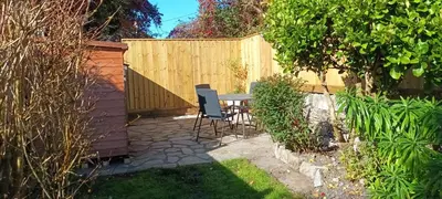 a patio with a table and chairs in a backyard at Hillside Cottage in Wadebridge