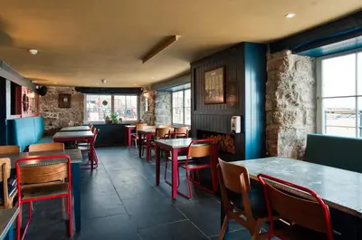a restaurant dining room with tables and chairs at Lifeboat Inn in St Ives