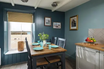 a dining room with blue walls and a wooden table at Lifeboat Inn in St Ives
