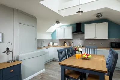 a kitchen with a wooden table with a bowl of fruit on it at Lifeboat Inn in St Ives