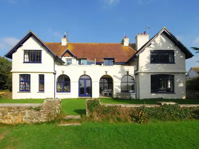 a large white house with a green yard at Bishops View in Polzeath