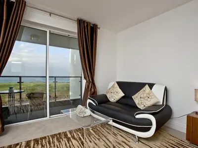 a living room with a couch and a glass table at Fistral View At Bredon Court in Newquay