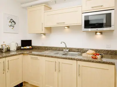 a kitchen with a sink and a microwave at 50 Bredon Court in Newquay