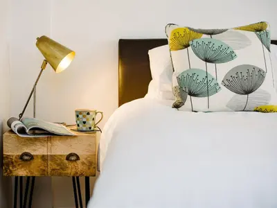 a bedroom with a bed with a lamp and a table at 50 Bredon Court in Newquay