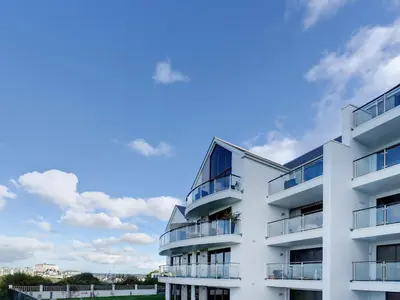 an apartment building with a blue sky in the background at Bredon Court, Poseidon Penthouse in Newquay