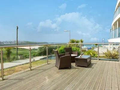 a balcony with chairs and a table on a building at Fistral View - 3 Cribbar in Newquay