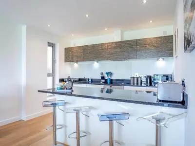 a kitchen with a counter and stools in a room at 7 Cribbar in Newquay