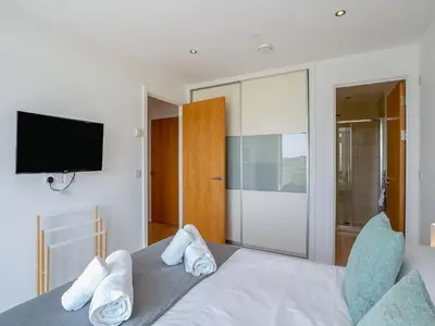 a bedroom with a bed with a tv on the wall at 7 Cribbar in Newquay