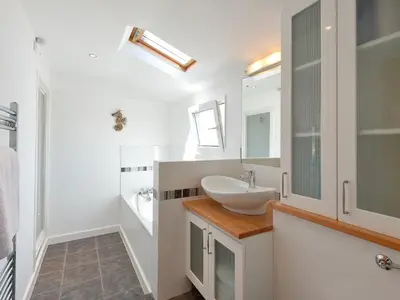 a white bathroom with a sink and a mirror at Florizel in Falmouth