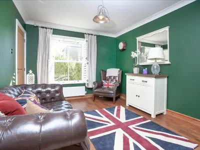 a living room with a leather couch and a mirror at Headland Views in Newquay