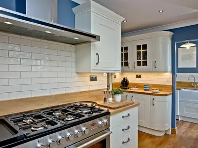 a kitchen with white cabinets and a stove top oven at Headland Views in Newquay