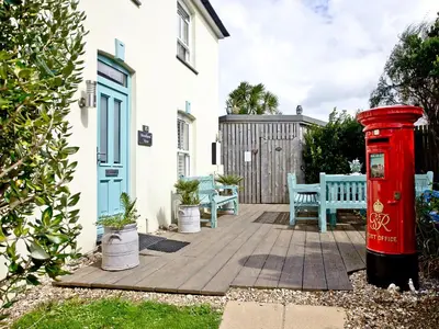 a red post box and benches in front of a house at Headland Views in Newquay