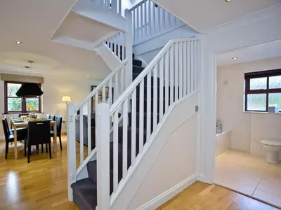 a white staircase in a home with a dining room at Holly in Saint Wenn