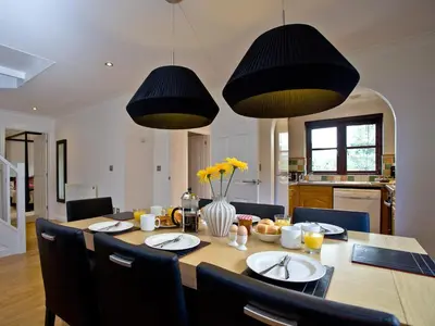 a dining room with a table and two lights at Holly in Saint Wenn