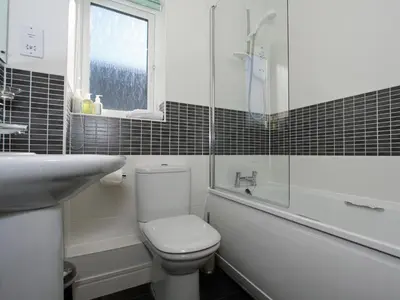 a white bathroom with a toilet and a sink at 6 Jubilee Close in St Merryn