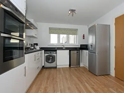 a kitchen with a stainless steel refrigerator and a dishwasher at 6 Jubilee Close in St Merryn