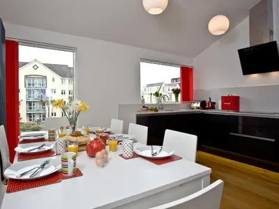 a white dining room with a white table and chairs at Above Towan At 8 Quay Court in Newquay