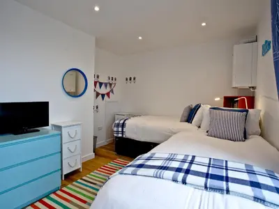 a bedroom with two beds and a tv in it at Above Towan At 8 Quay Court in Newquay