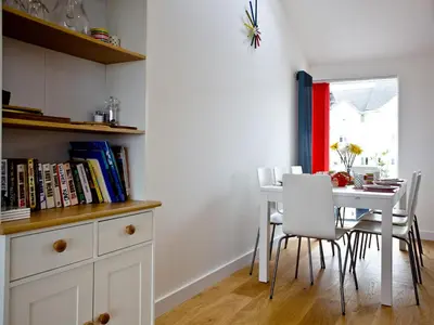 a dining room with a white table and chairs at Above Towan At 8 Quay Court in Newquay