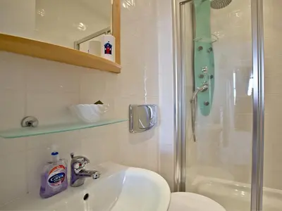 a bathroom with a sink and a shower at Quay House, Porth Beach in Newquay