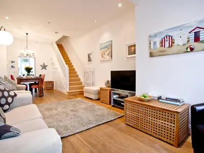 a living room with a couch and a tv at Quay House, Porth Beach in Newquay