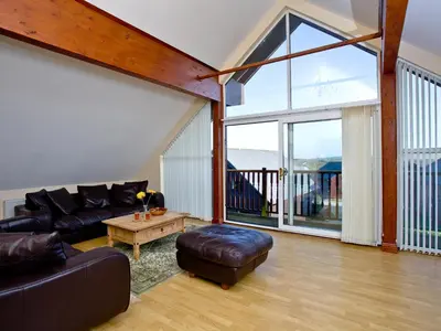 a living room with a couch and a table at Ash Lodge - Retallack in Saint Columb Major