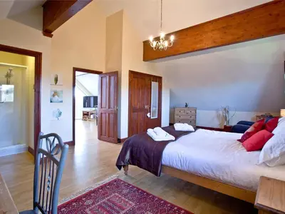 a bedroom with a large bed and a table at Ash Lodge - Retallack in Saint Columb Major