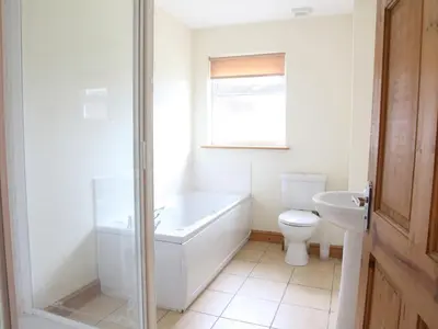 a white bathroom with a tub and a toilet at Beech Lodge - Retallack Resort in Saint Columb Major