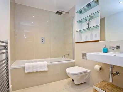 a bathroom with a toilet and a tub and a sink at 9 The Whitehouse in Mawgan Porth