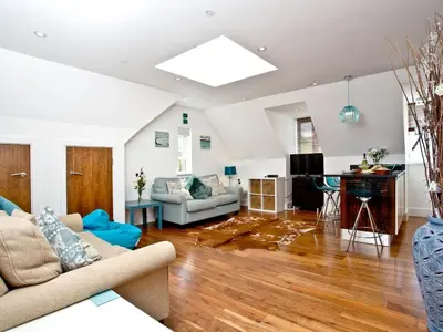 a living room with a couch and a table at 9 The Whitehouse in Mawgan Porth