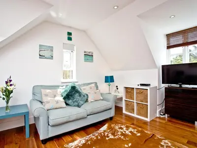 a living room with a couch and a tv at 9 The Whitehouse in Mawgan Porth