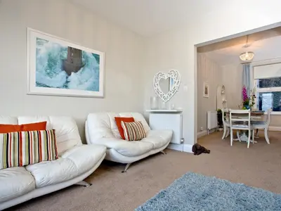 a living room with two white couches and a table at Kerensa in Looe