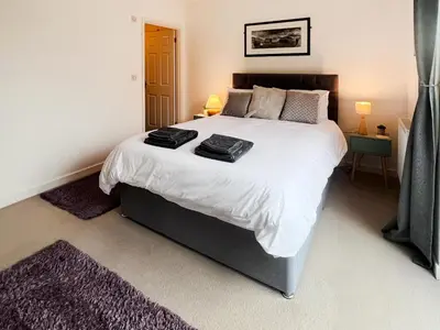 a bedroom with a large bed with two towels on it at 3 Waterwheel Apartment in Charlestown