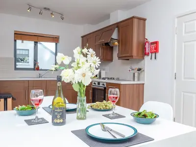 a table with a vase of flowers and wine glasses at 3 Waterwheel Apartment in Charlestown