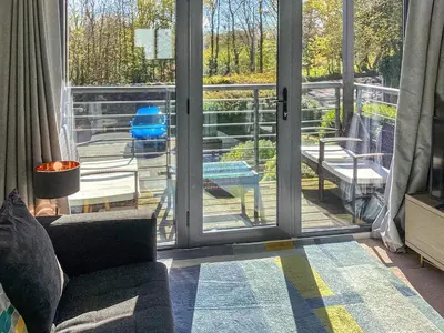 a living room with a sliding glass door at 3 Waterwheel Apartment in Charlestown