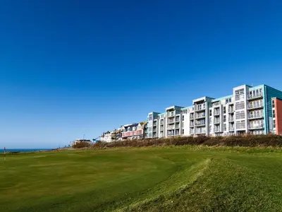 a large apartment building on top of a green field at 12 Zinc in Newquay