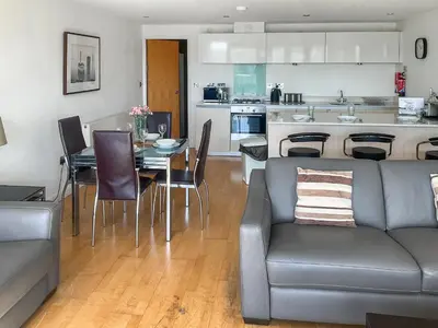 a living room and kitchen with a couch and a table at 12 Zinc in Newquay