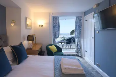 a hotel room with a bed and a balcony at The Slipway B&B in Port Isaac